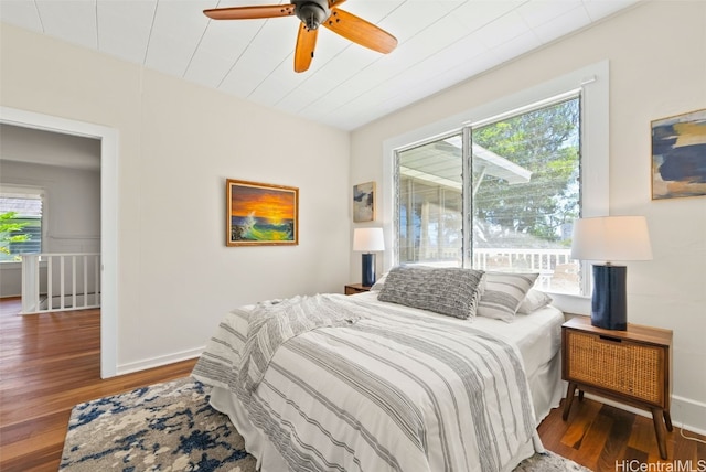 bedroom with multiple windows, wood-type flooring, and ceiling fan