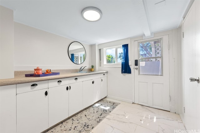 interior space with beamed ceiling and vanity