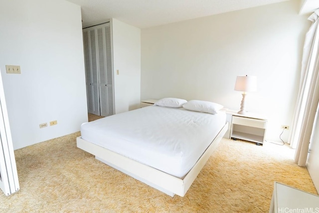 bedroom with light carpet and a closet