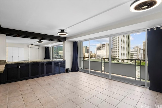 interior space featuring light tile patterned floors, an AC wall unit, and a healthy amount of sunlight