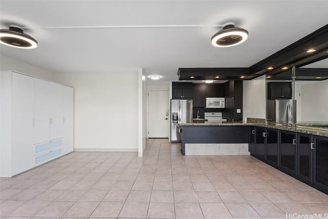 kitchen with stone countertops, light tile patterned floors, and white appliances