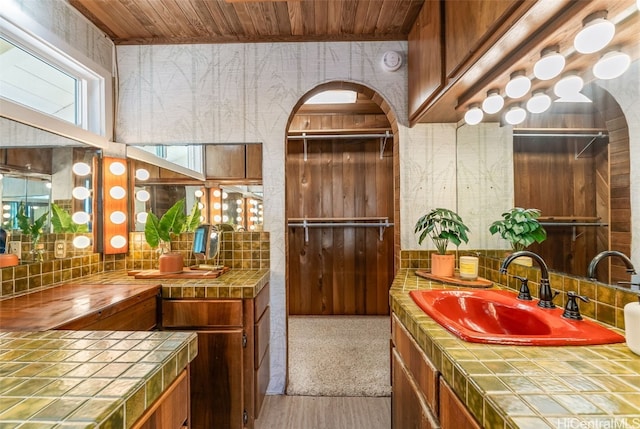 bathroom featuring vanity, wood ceiling, wood-type flooring, and decorative backsplash