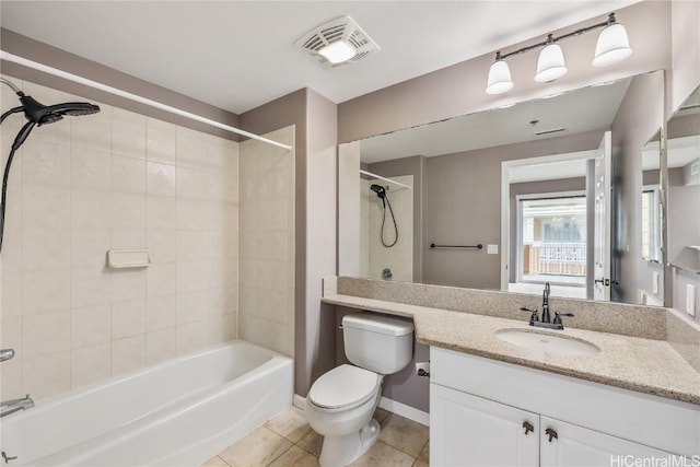 full bathroom featuring tile patterned flooring, vanity, tiled shower / bath combo, and toilet