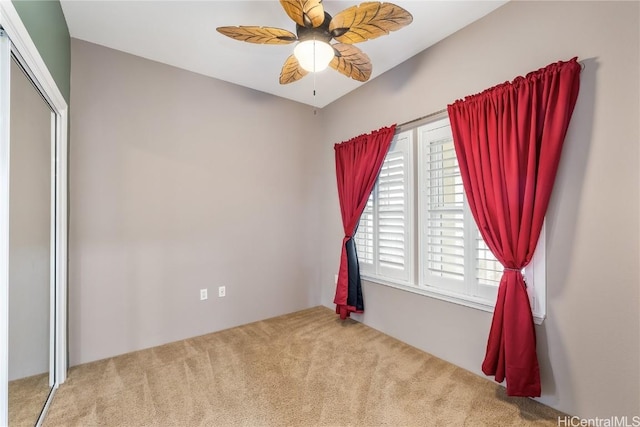 unfurnished bedroom with carpet flooring, ceiling fan, and a closet