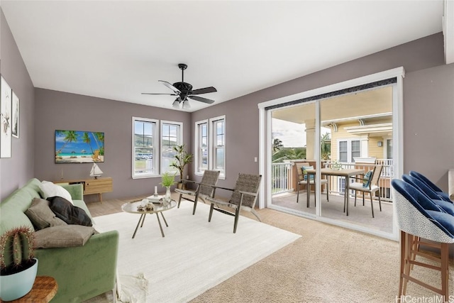 living room with ceiling fan and light colored carpet