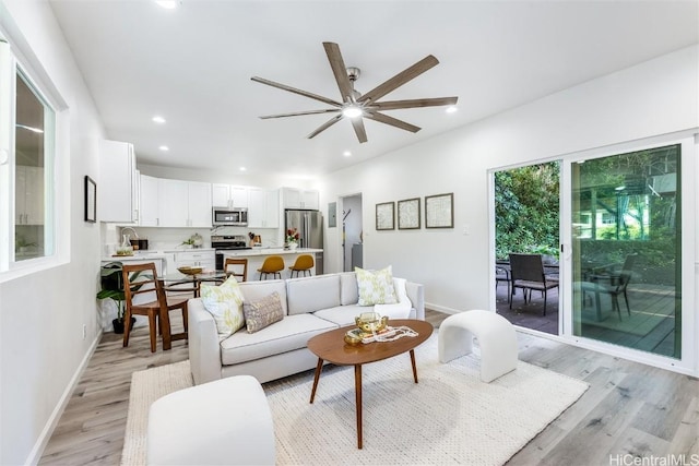 living room with light hardwood / wood-style flooring and ceiling fan