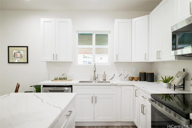 kitchen with white cabinetry, stainless steel appliances, and sink