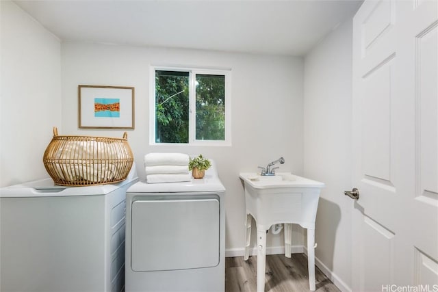 laundry area with washing machine and clothes dryer and wood-type flooring