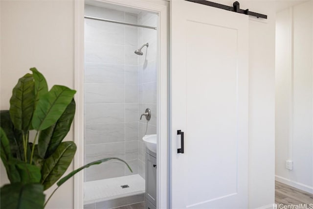 bathroom featuring hardwood / wood-style flooring and tiled shower