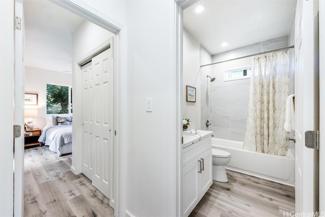 full bathroom with shower / bath combination with curtain, toilet, hardwood / wood-style floors, and a wealth of natural light