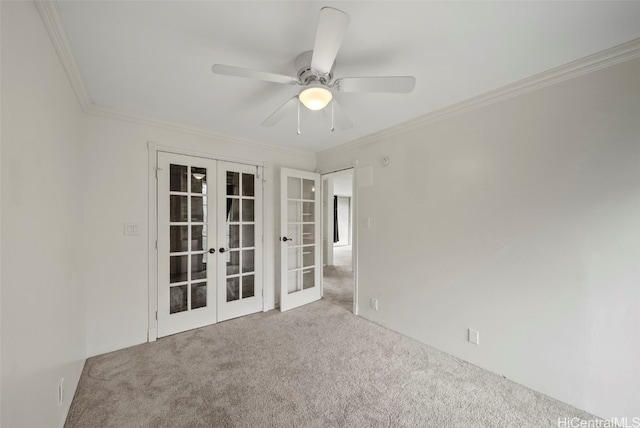 carpeted empty room with french doors, ceiling fan, and crown molding