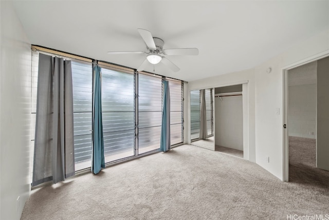 unfurnished bedroom featuring multiple windows, access to outside, ceiling fan, light carpet, and a closet