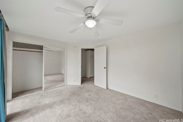 unfurnished bedroom featuring light colored carpet, ceiling fan, and a closet