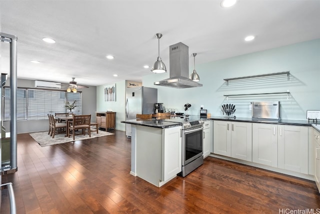 kitchen with white cabinetry, appliances with stainless steel finishes, kitchen peninsula, pendant lighting, and island exhaust hood