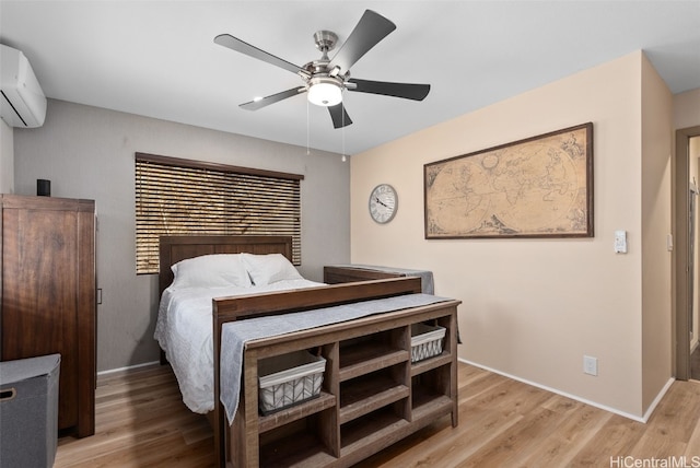 bedroom featuring light hardwood / wood-style flooring, an AC wall unit, and ceiling fan