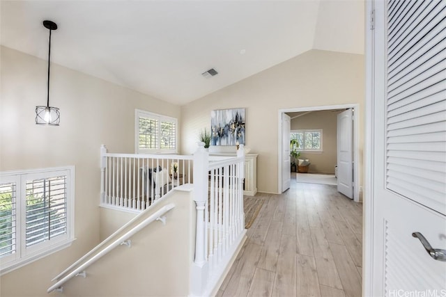 hallway with lofted ceiling and light hardwood / wood-style floors