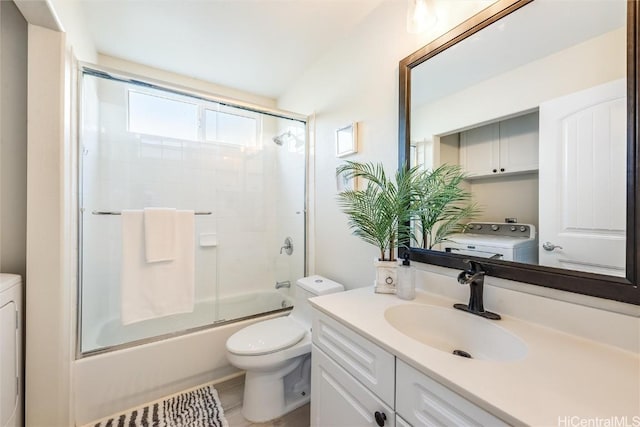 full bathroom with vanity, washer / dryer, shower / bath combination with glass door, and toilet