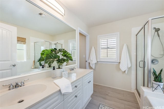 bathroom featuring plenty of natural light, a shower with shower door, and hardwood / wood-style floors