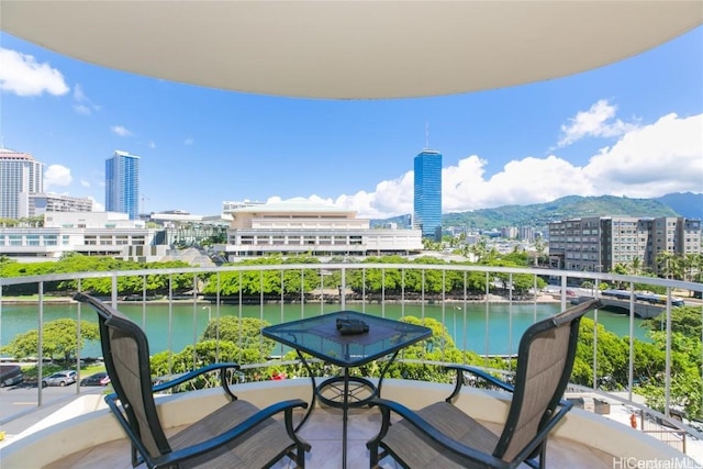 balcony featuring a water and mountain view