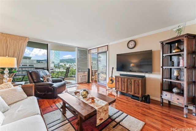 living room featuring hardwood / wood-style floors, crown molding, and floor to ceiling windows