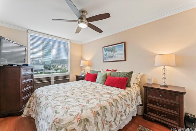 bedroom with ornamental molding, dark wood-type flooring, and ceiling fan