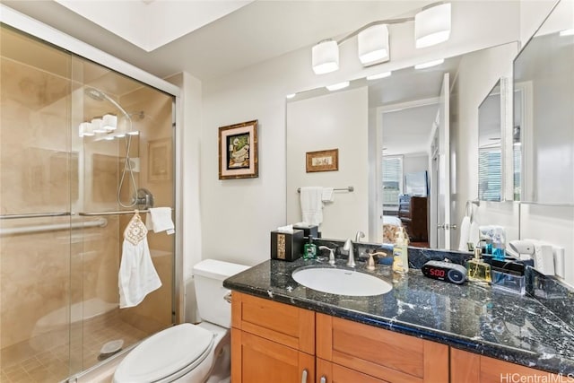 bathroom with walk in shower, vanity, and toilet