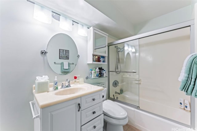 full bathroom featuring vanity, combined bath / shower with glass door, and toilet