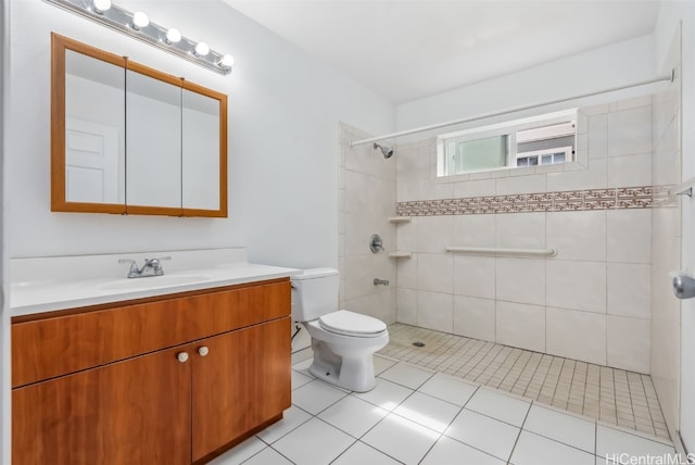 bathroom featuring vanity, tile patterned floors, toilet, and a tile shower