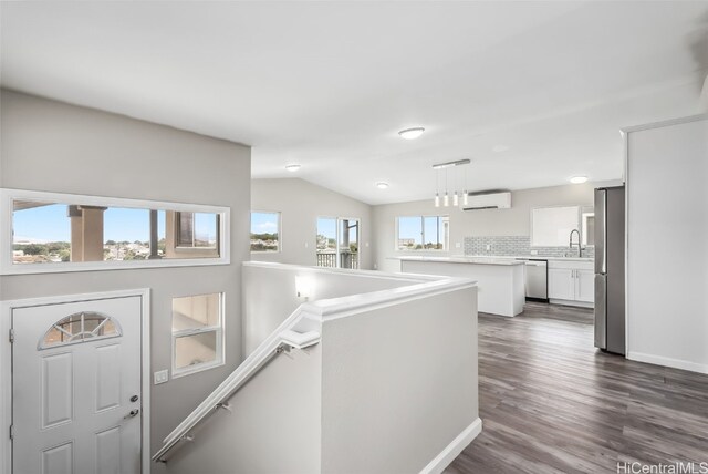 corridor with sink, a wall mounted air conditioner, a wealth of natural light, and dark hardwood / wood-style floors