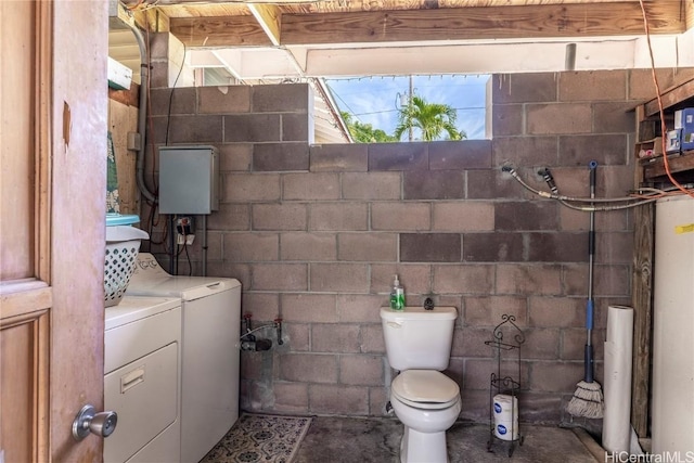 bathroom featuring concrete floors, washing machine and dryer, water heater, and toilet