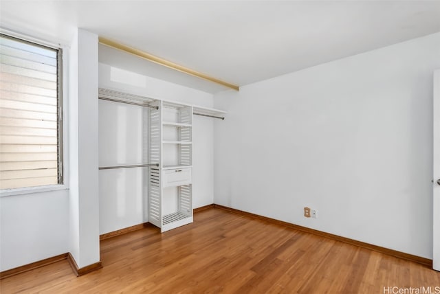 unfurnished bedroom with light wood-style floors, baseboards, and a closet