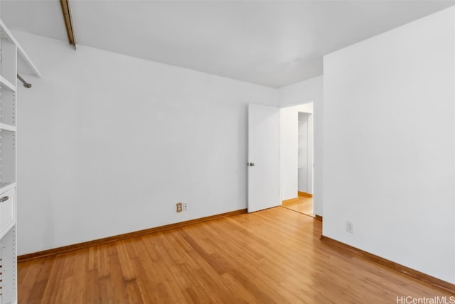 unfurnished room with light wood-type flooring and baseboards