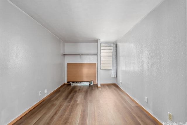 unfurnished living room featuring baseboards and wood finished floors