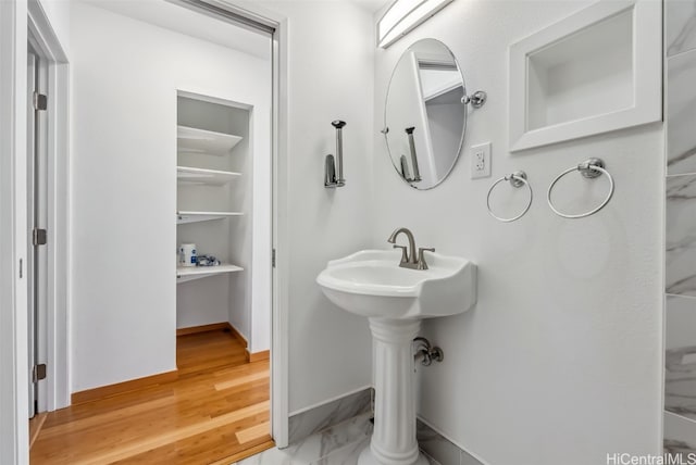 bathroom with baseboards and wood finished floors