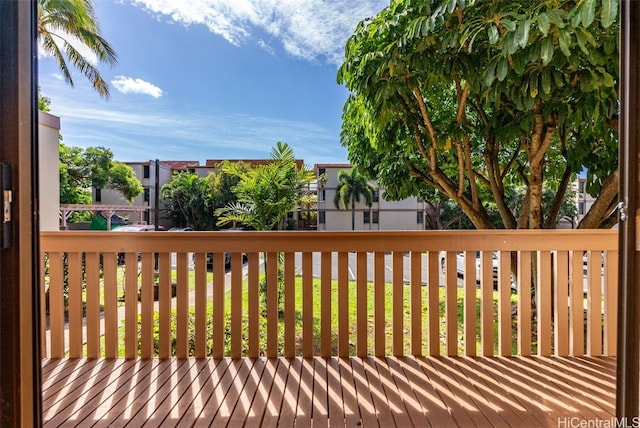 wooden terrace featuring a lawn