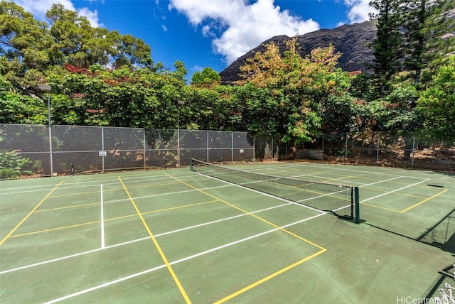 view of sport court featuring fence and a mountain view