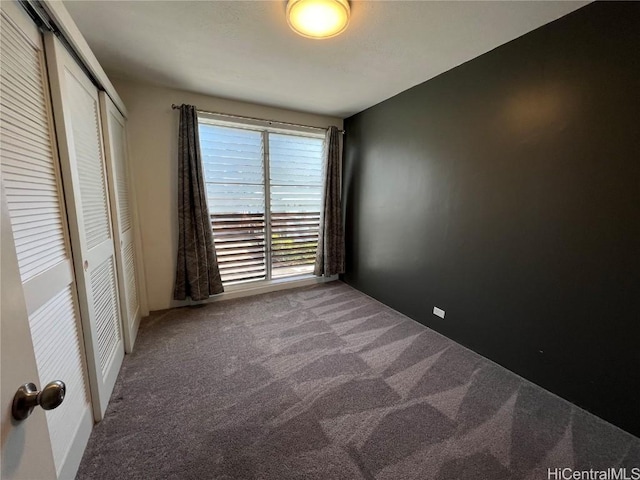 unfurnished bedroom featuring carpet flooring and a closet