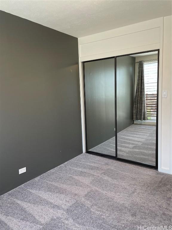 unfurnished bedroom with carpet and a closet