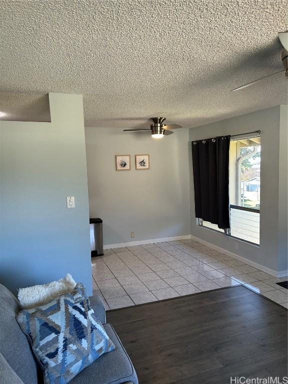 interior space featuring ceiling fan, hardwood / wood-style floors, and a textured ceiling