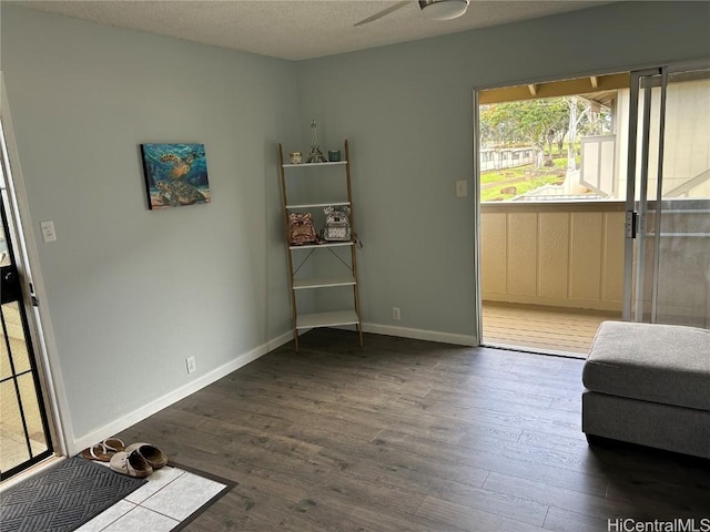 sitting room featuring ceiling fan, hardwood / wood-style floors, and a textured ceiling