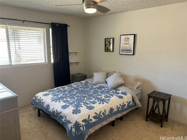 bedroom featuring light carpet, ceiling fan, and a textured ceiling