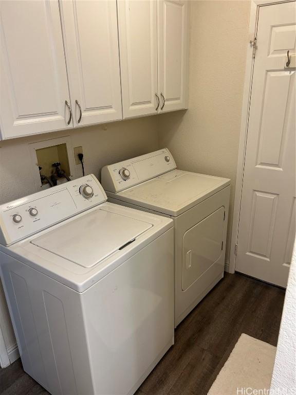 laundry area featuring dark wood-type flooring, independent washer and dryer, and cabinets