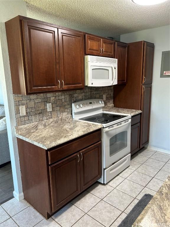 kitchen with backsplash, white appliances, a textured ceiling, and light tile patterned floors