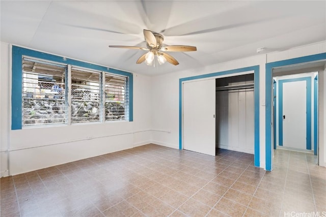 unfurnished bedroom with ceiling fan and a closet