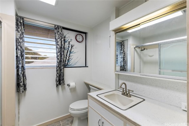 bathroom with vanity, toilet, and a shower with door