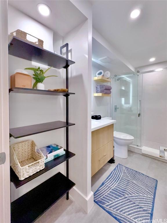 bathroom featuring vanity, toilet, and a shower with door