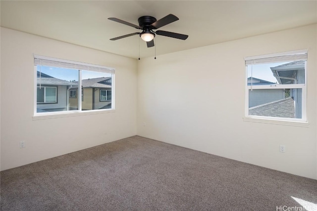 carpeted spare room featuring ceiling fan