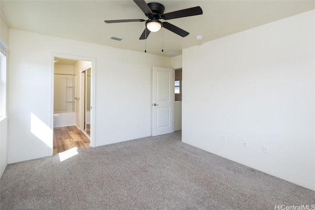 unfurnished bedroom with ensuite bathroom, ceiling fan, and carpet flooring