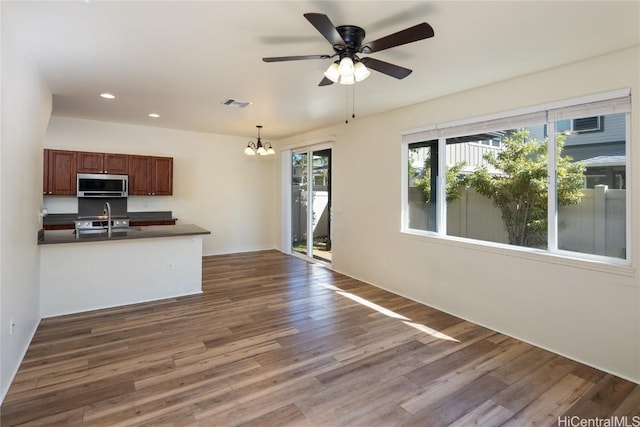 kitchen with ceiling fan with notable chandelier, decorative light fixtures, dark hardwood / wood-style flooring, and sink