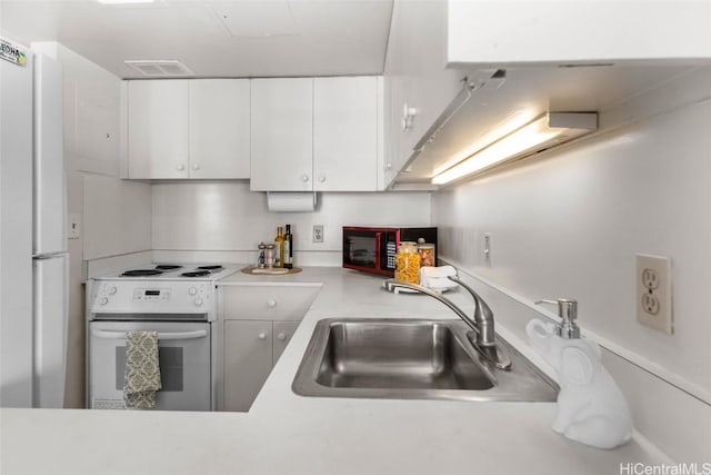 kitchen with white cabinetry, sink, and white appliances